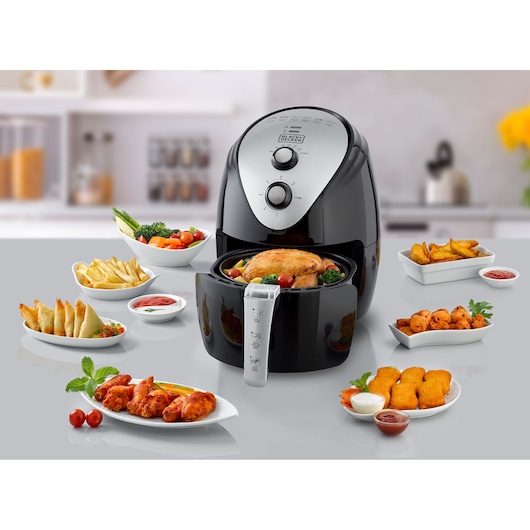 BLACKDECKER AF150 air fryer front angle with prepared food dishes on a kitchen countertop.