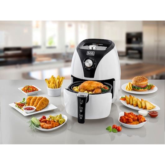 BLACKDECKER AF220 air fryer front view with assorted fried foods on a kitchen counter.