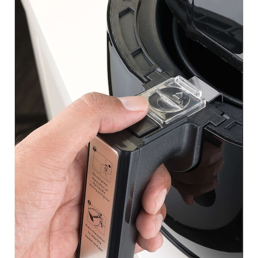 Photo of BLACKDECKER AF400 air fryer handle with hand pressing release button, showing close-up operational detail.