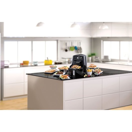 BLACKDECKER AF550 air fryer with food plates on kitchen island, front angle.