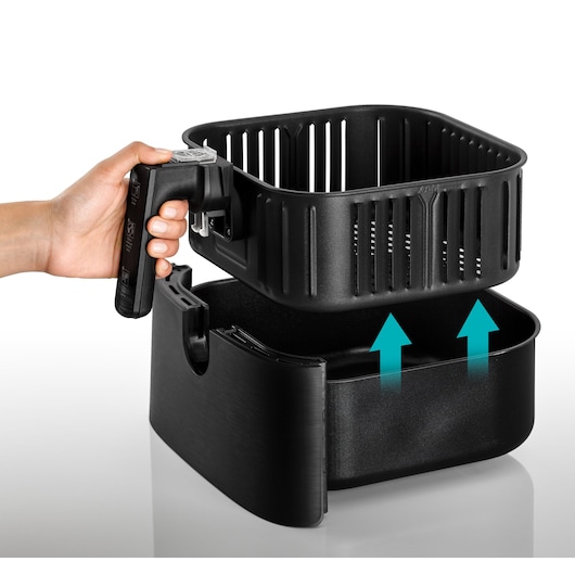 BLACKDECKER AF700 air fryer basket being lifted from black base, hand holding the detachable handle, white background.