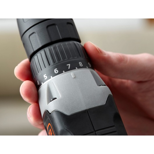 Close-up photo of BLACKDECKER BCD001C2K cordless drill with hand adjusting torque settings, product in use.