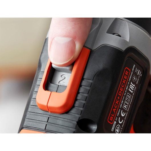 Close-up photo of a hand adjusting the speed switch on a BLACK+DECKER BCD003C2K power tool.