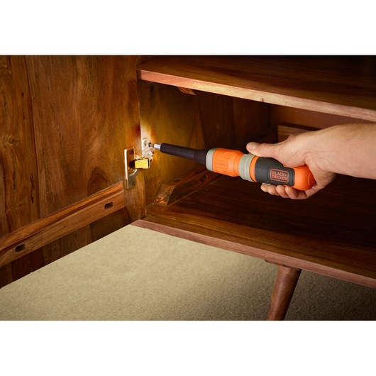 BLACKDECKER BCF603C cordless screwdriver used on cabinet hinge in home setting.