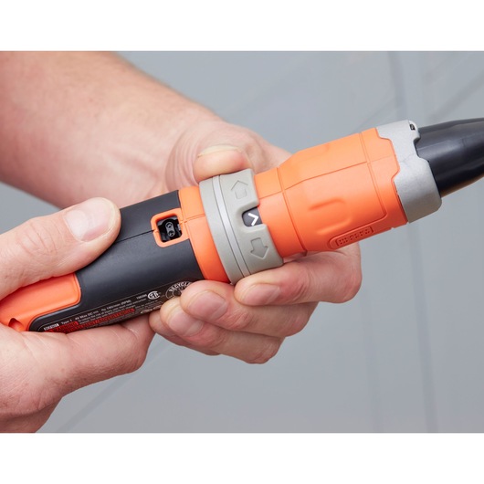 Photo of a person holding a BLACK+DECKER BCF603C cordless screwdriver, showing the orange and black grip and control buttons.