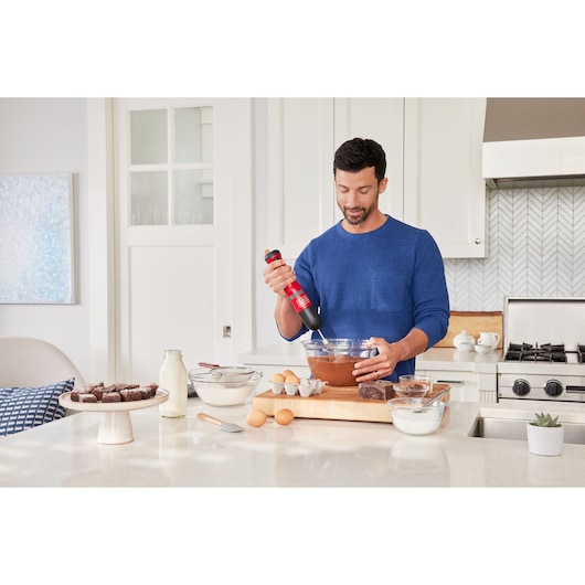 BLACKDECKER BCKM101WHFF kitchen mixer in use mixing batter in glass bowl on kitchen counter.