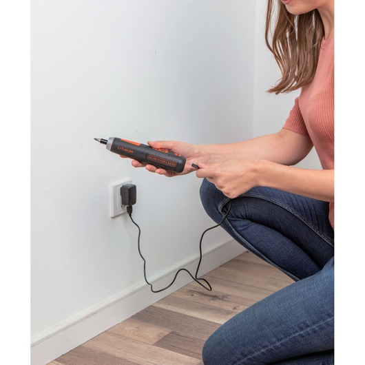 Photo of BLACKDECKER BD40K27 cordless screwdriver being charged with a wall adapter.