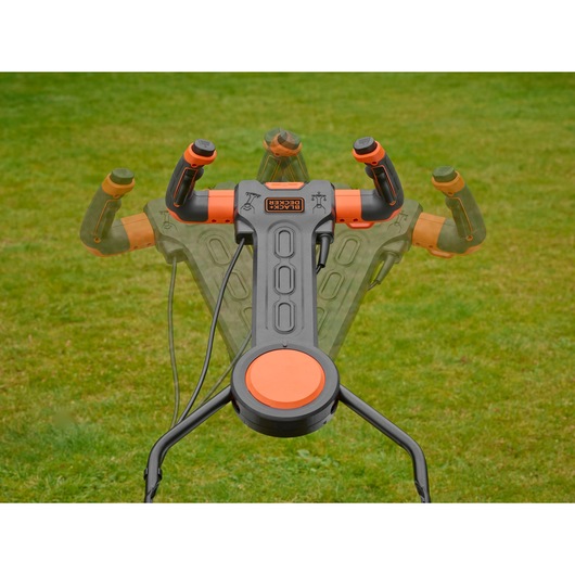 BLACKDECKER BEMW481ES lawn mower adjustable handle in black and orange on grass, closeup photography.