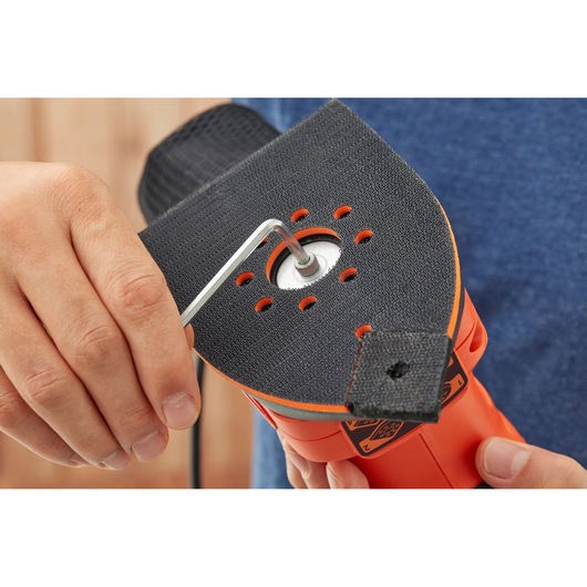 BLACKDECKER BEW200 sander closeup showing pad attachment with hex key, held in hand.