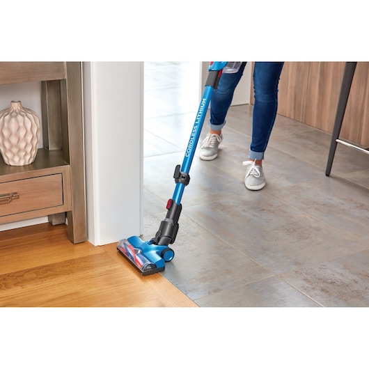 BLACKDECKER BHFE620J cordless stick vacuum cleaning wood and tile floor, blue, indoor photo.