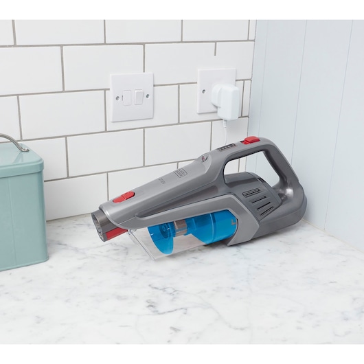 BLACKDECKER BHFE620J handheld vacuum cleaner charging on kitchen counter, side angle.