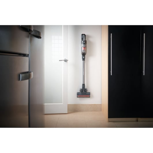 BLACKDECKER BHFEA18D1 cordless stick vacuum mounted on kitchen wall, upright angle.