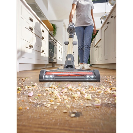 BLACKDECKER BHFEV36B2D cordless stick vacuum cleaning debris on kitchen floor, front angle.