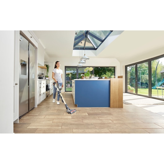 BLACKDECKER BHFEV36B2D cordless stick vacuum cleaner used on kitchen tiles near blue island.