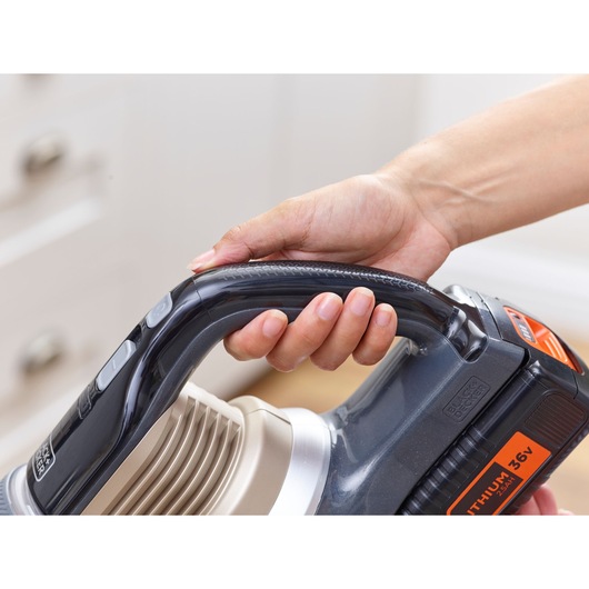BLACKDECKER BHFEV36B2D cordless vacuum handle close-up with hand holding, showing control buttons.