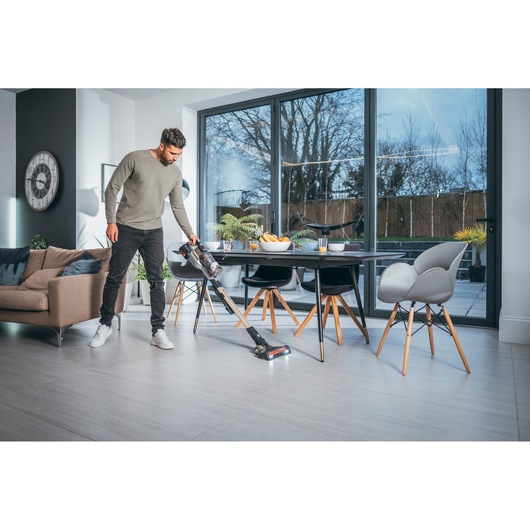 Photo of BLACKDECKER BHFEV36B2D cordless stick vacuum cleaning modern living and dining area.