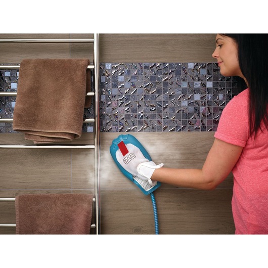 Photo of BLACK+DECKER BHSM166DSM steam cleaning glove cleaning bathroom tile wall near a towel rack.