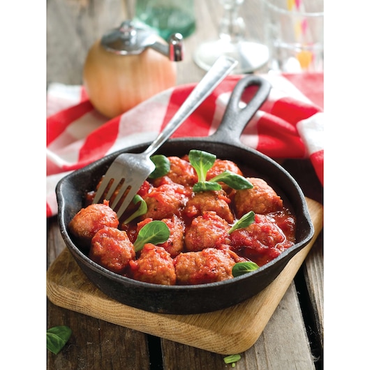 BLACKDECKER BX580 cast iron skillet of meatballs in tomato sauce with greens, fork on wooden board, front angle