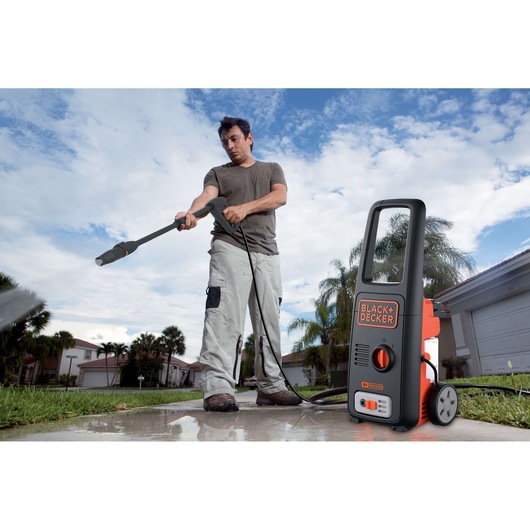 Photo of BLACK+DECKER BXPW1400E pressure washer in use cleaning outdoor pavement.