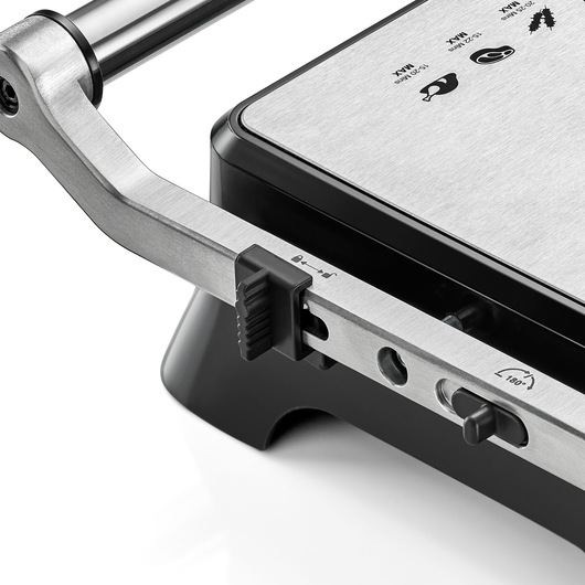BLACKDECKER CG1400 grill close-up, showing stainless steel handle, control switch, and icons on top plate, angled view.