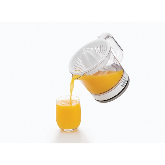 BLACKDECKER CJ675 citrus juicer pouring orange juice into a glass, side angle on white background.