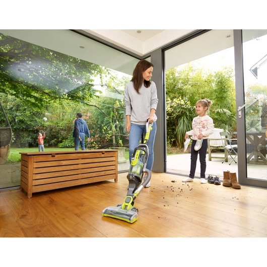 BLACKDECKER CUA525BHA upright vacuum cleaner cleaning wooden floor in a modern home interior.