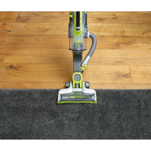 Photo of BLACKDECKER CUA525BHA cordless vacuum cleaner on carpet and hardwood floor, top view.