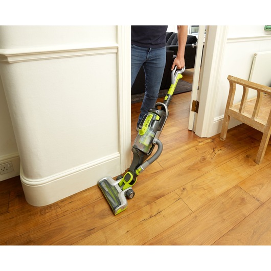 BLACKDECKER CUA525BHA cordless vacuum cleaner in use on wooden floor in home interior.