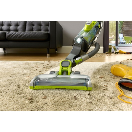 BLACKDECKER CUA525BHA cordless vacuum cleaning carpet, close-up view in living room.