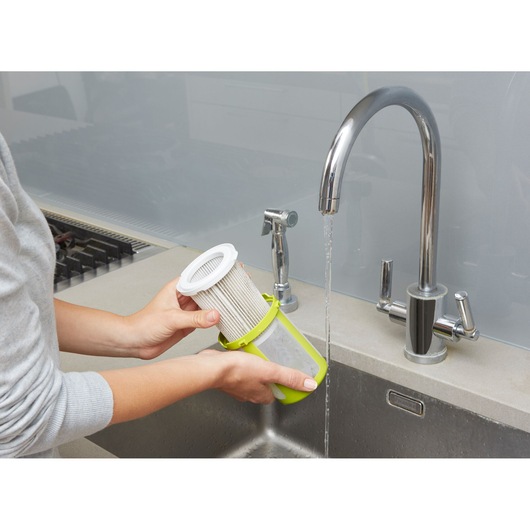 BLACKDECKER CUA525BHA filter being rinsed under kitchen faucet, product photography.