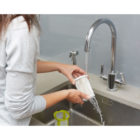BLACKDECKER CUA525BHA vacuum filter being rinsed under faucet at kitchen sink, close-up angle