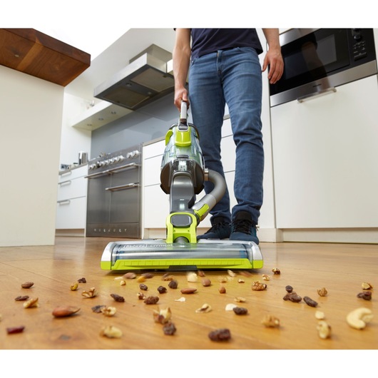 BLACKDECKER CUA525BHA cordless vacuum cleaner picking up nuts and raisins on kitchen floor, front angle