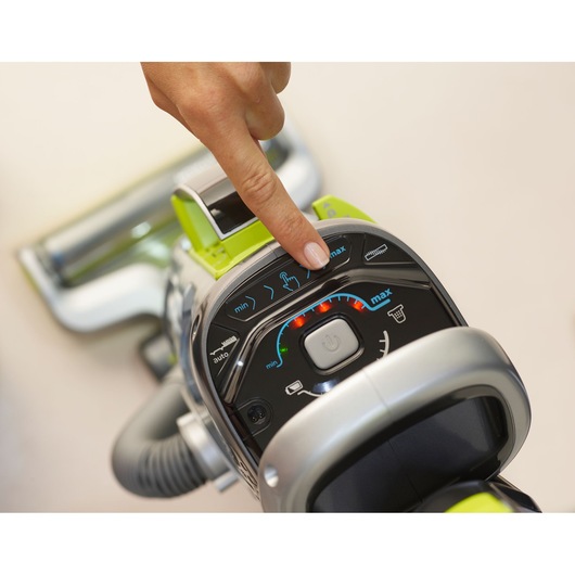 BLACKDECKER CUA525BHA vacuum cleaner control panel close-up, finger pressing a button.