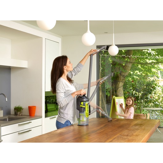 BLACKDECKER CUA525BHA vacuum cleaner with extension hose used for cleaning kitchen surfaces.