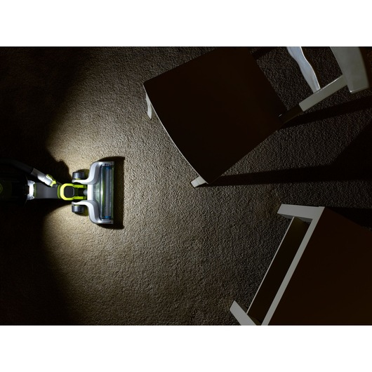BLACKDECKER CUA525BHA vacuum cleaner cleaning carpet near chairs, top view, bright lighting, photography.