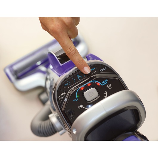 BLACKDECKER CUA525BHP vacuum cleaner control panel close-up with finger pressing button.