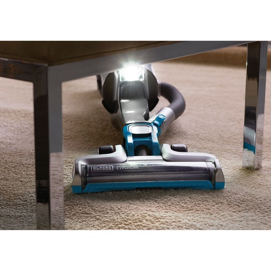 BLACKDECKER CUA525BH cordless vacuum cleaner cleaning carpet under furniture, front view, photography.