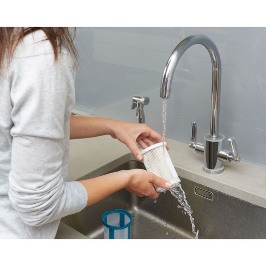 BLACKDECKER CUA525BH filter being rinsed under faucet in kitchen sink, product demonstration.