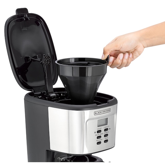 Photo of BLACK+DECKER DCM85 coffee maker with open lid, hand removing black filter basket, front angle.