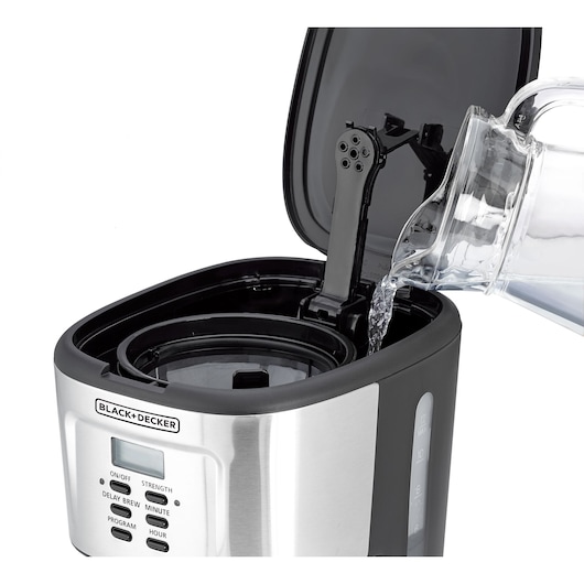 Photo of BLACK+DECKER DCM85 coffee maker with water being poured into open reservoir, front angle view.