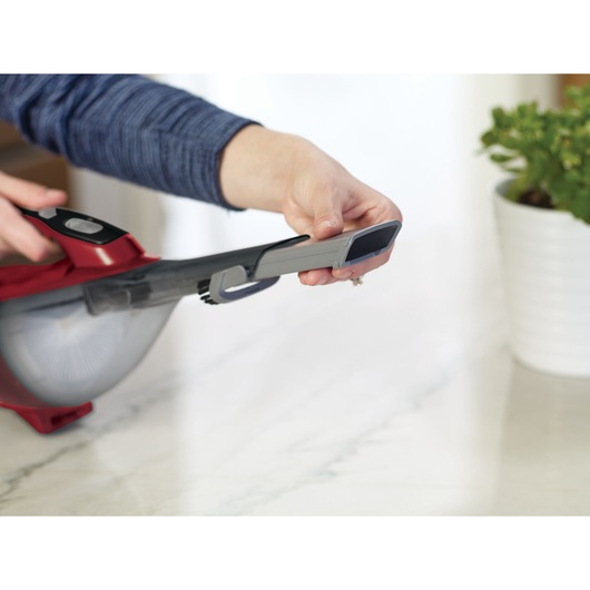 Photography of BLACKDECKER DVA315J handheld vacuum being used on a marble surface.