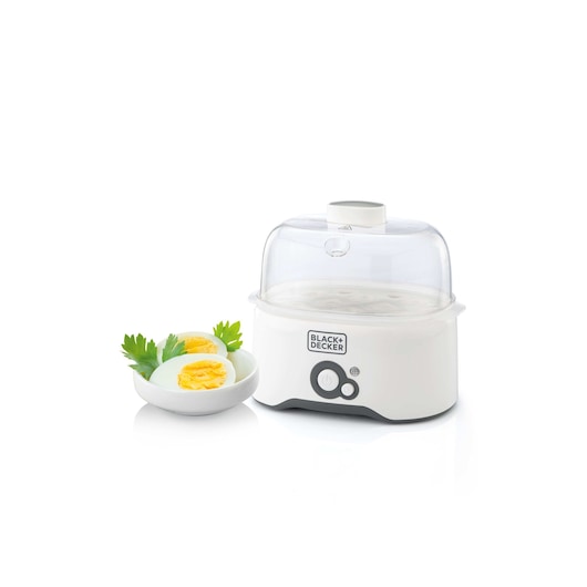 A BLACK+DECKER egg cooker with a white base and transparent lid, shown next to a plate containing sliced boiled eggs garnished with parsley.