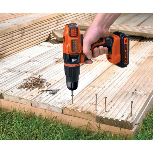 Photo of BLACK+DECKER EGBL188KB cordless drill being used on wooden decking, visible screws and drill bits nearby.