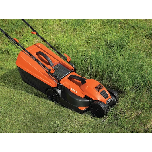 An orange and black BLACK+DECKER electric lawn mower with a 32 cm cutting width is shown cutting tall grass.