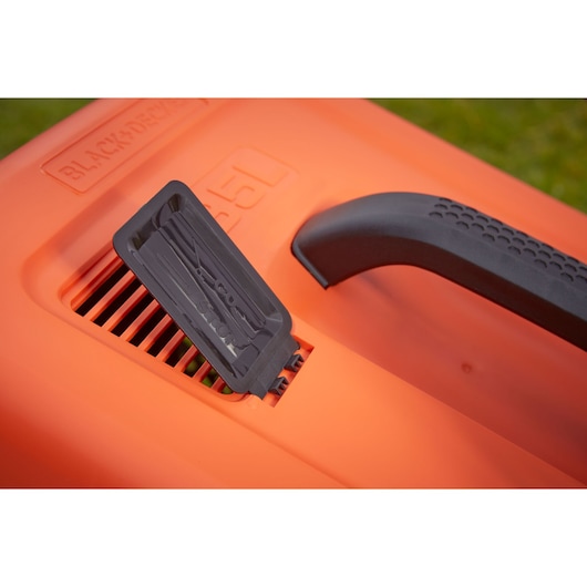 Close-up of an orange BLACK+DECKER lawn mower featuring a black handle and a black lever near an air vent.