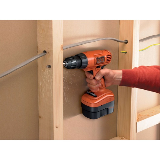 Photo of BLACKDECKER EPC12CAB cordless drill being used to drill through a wooden stud with wiring nearby.
