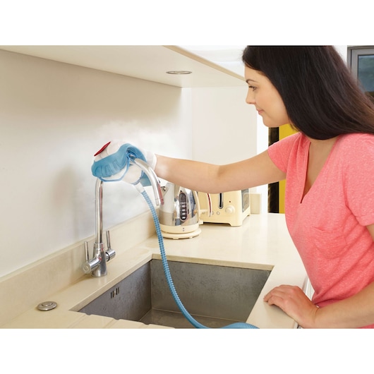 BLACKDECKER FSH10SMP steam cleaning glove used to clean kitchen faucet and countertop.