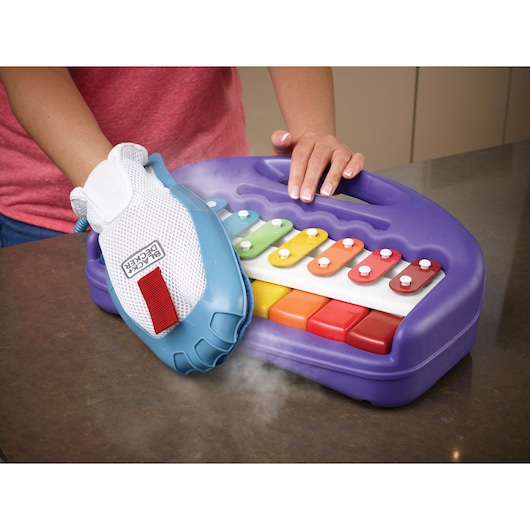 BLACKDECKER FSH10SMP steam cleaning glove on a colorful toy xylophone, close-up angle.