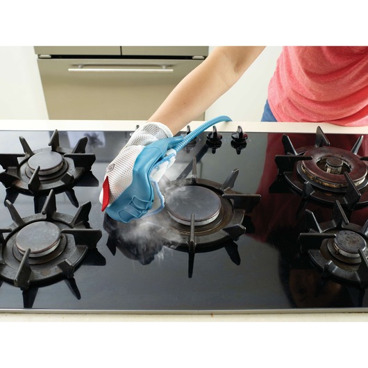 BLACKDECKER FSH10SMP steam cleaning glove cleaning a black gas stove top, close-up view.