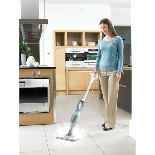 BLACKDECKER FSM1630 steam mop cleaning tile floor in modern kitchen, used by person.